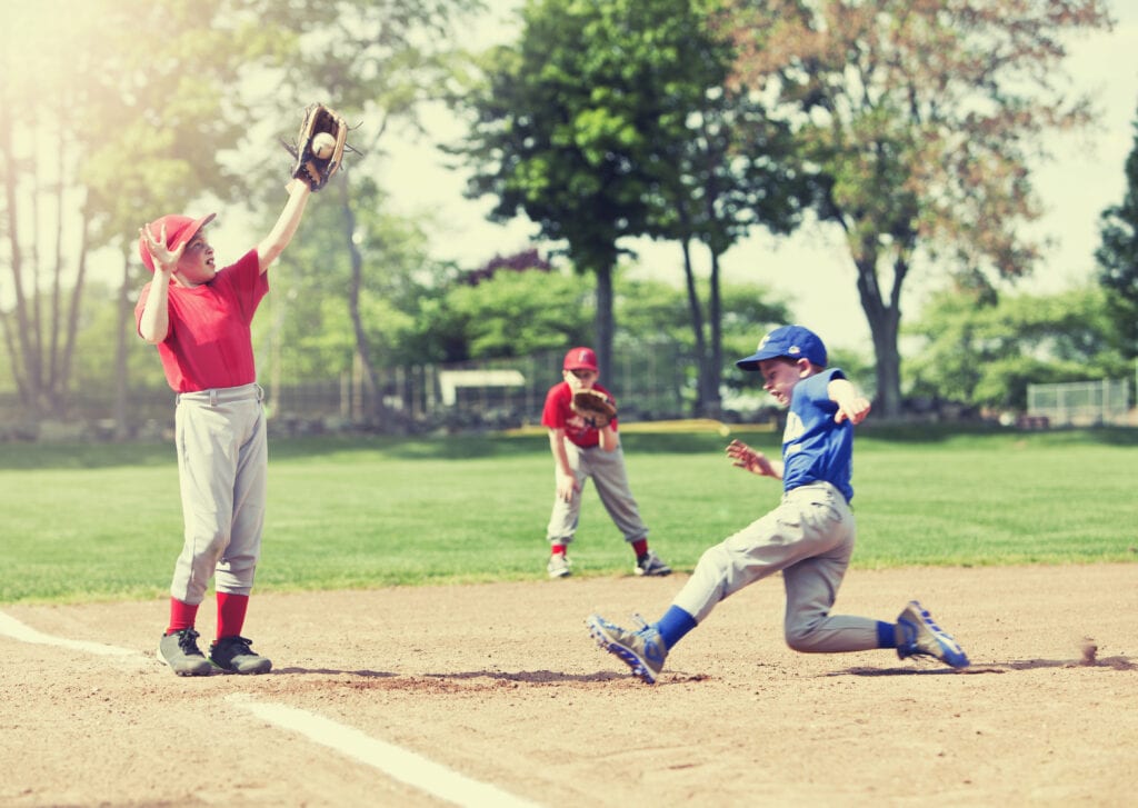 boy sliding into base during baseball game sports injuries