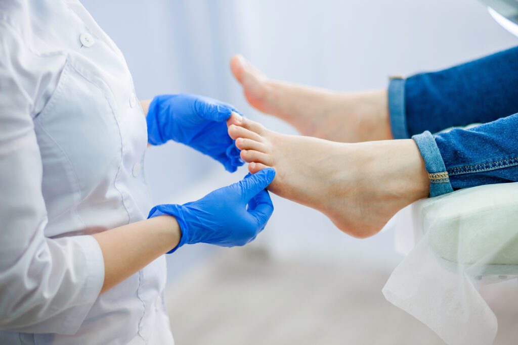 doctor examines ingrown toenails on female patient